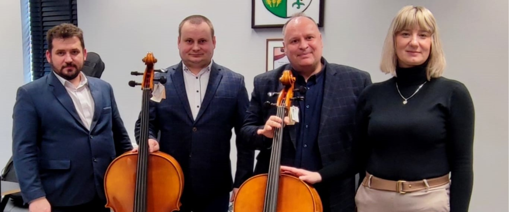Starosta Paweł Mostowy, Wicestarosta Renata Kosman i dwaj nauczyciele Szkołu Muzycznej prezentujący nowe wiolonczele